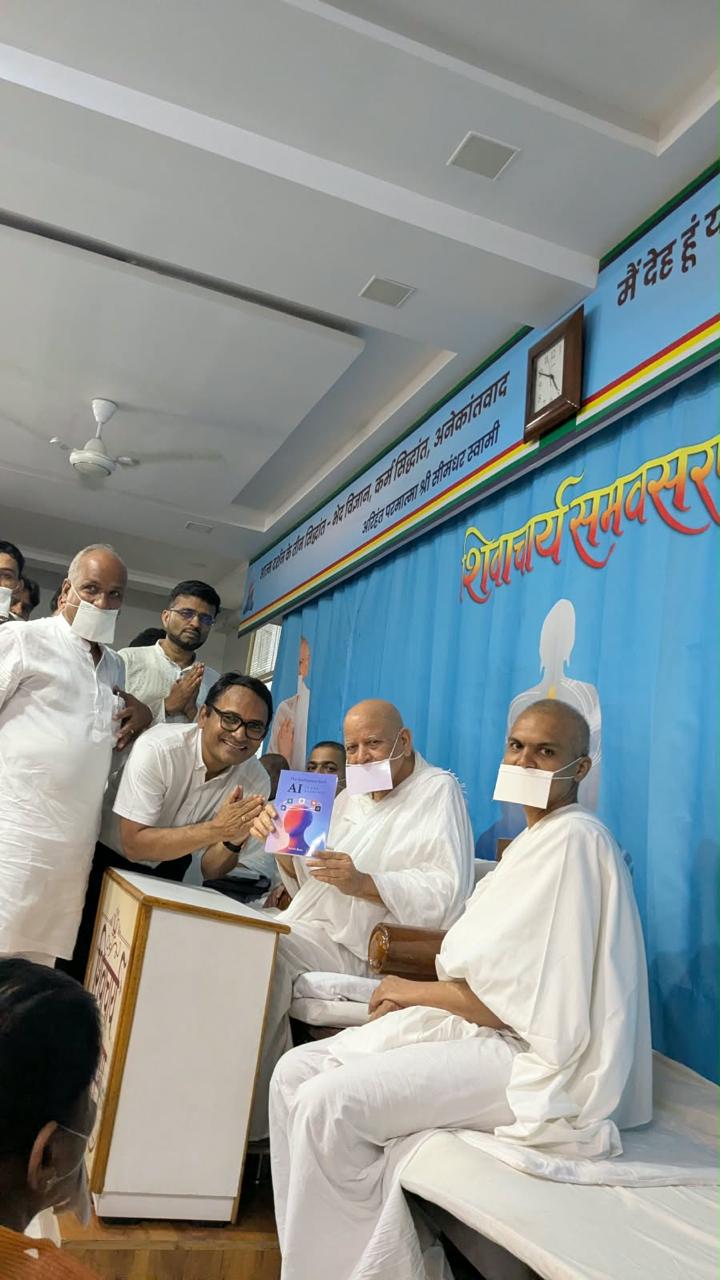 Satish Bora presenting his book on AI to Acharya Shri Shiv Muniji Maharaj Sahab in Surat